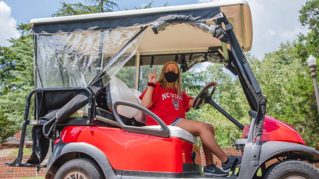 一个蒙着脸的司机在她的高尔夫球车里做狼