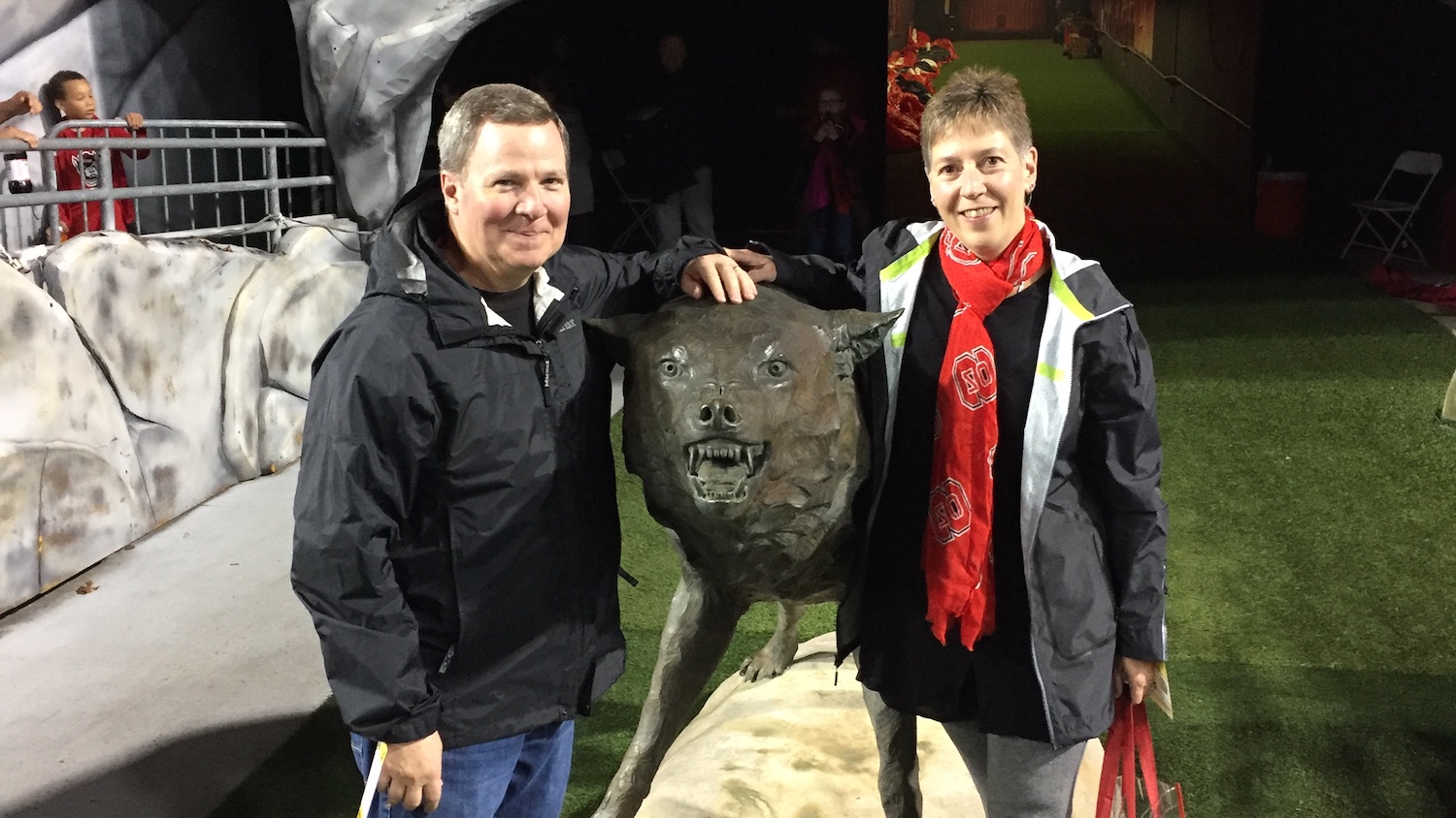 北卡罗来纳州基金会新任主席麦克·康斯坦丁诺和他的妻子洛莉站在一尊狼雕像旁。