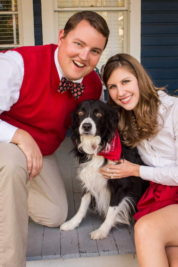 艾丽莎、凯尔和他们的狗狗穿着北卡罗来纳州的正式装备摆姿势