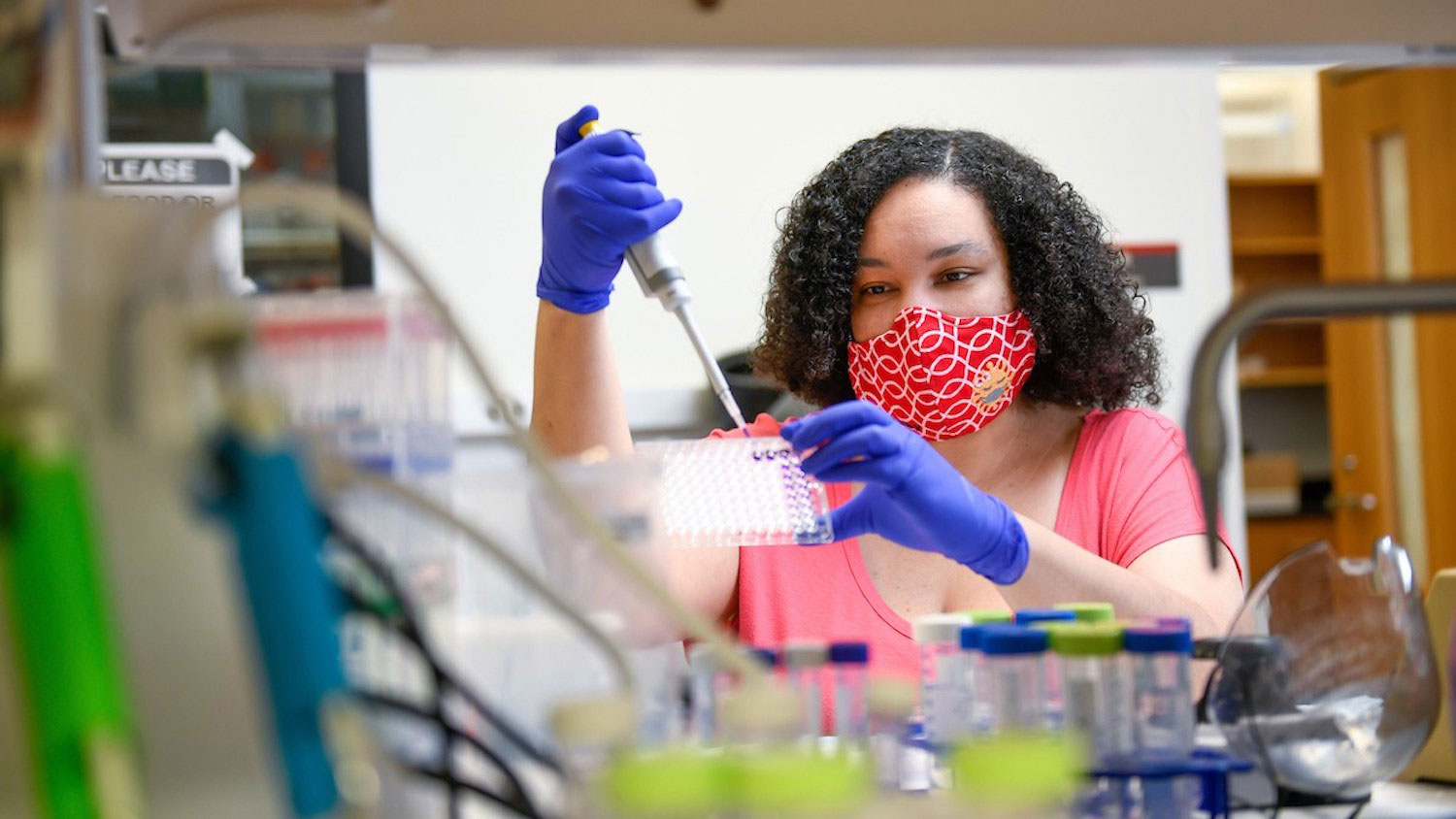 一个女学生在实验室里用吸管。
