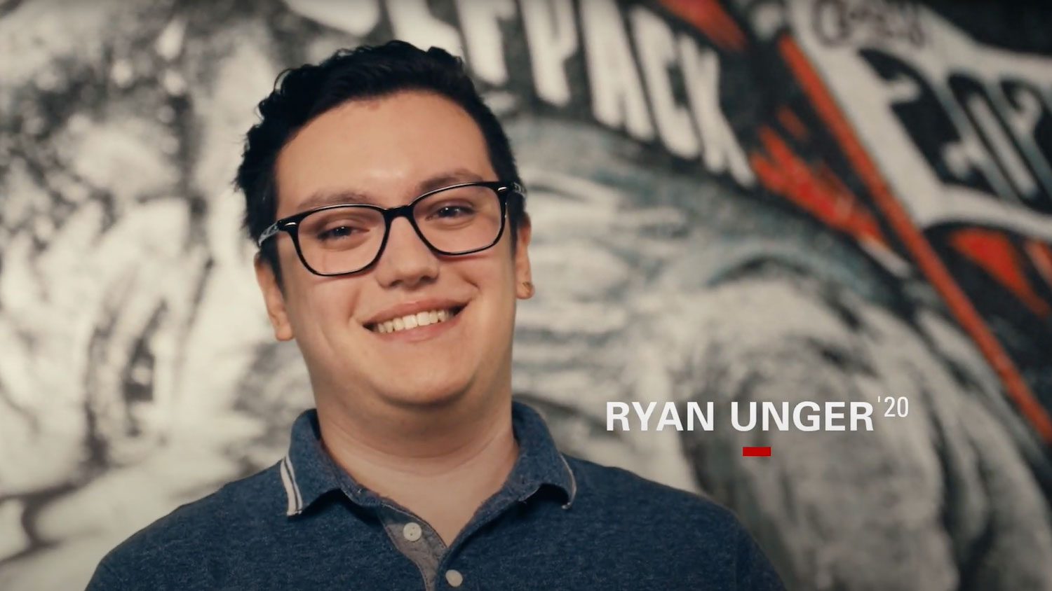 Ryan Unger在狼群主题艺术品前对着镜头微笑。